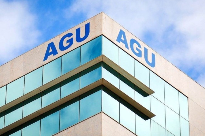 Fachada de um edifício com janelas de vidro azul e o nome 'AGU' em letras grandes no topo.